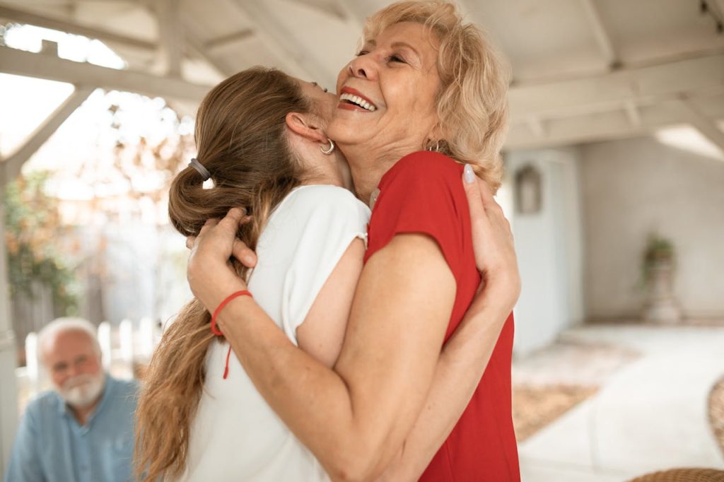 Heartwarming moment of two women sharing a joyful hug outdoors.